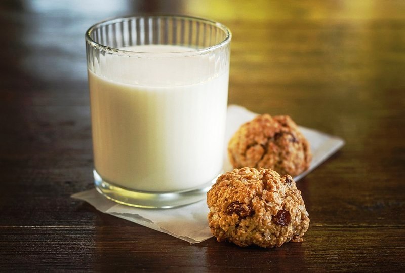 Склянка свіжого коров'ячого молока та печиво з родзинками.