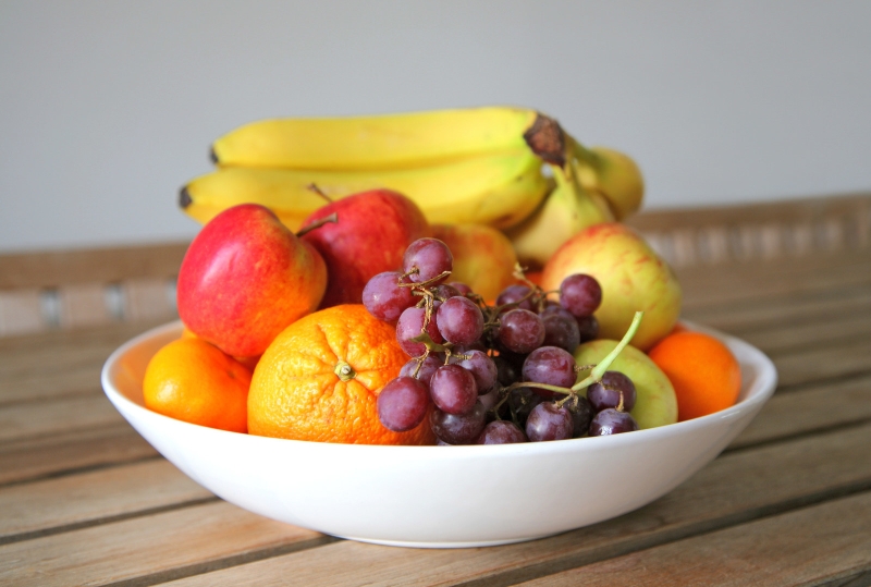 Тарілка з різноманітними свіжими фруктами і ягодами.