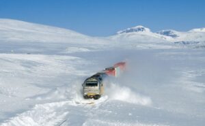 Вантажний поїзд мчить через снігові замети
